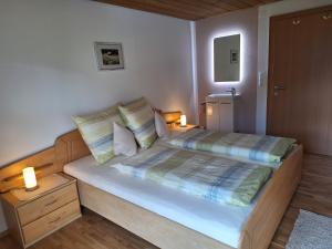 a bedroom with a large bed with two lamps on it at Ferienwohnung Angelina in Bartholomäberg