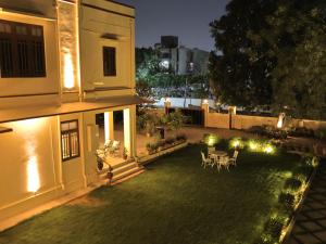a backyard at night with a table and chairs at Mundoota House in Jaipur