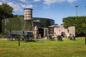 アッカースロートにあるBed&Bbq Longhornranchの建物の前の古い給水塔と荷馬車