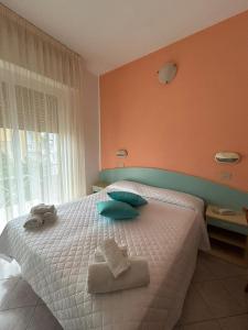 a bedroom with a bed with towels on it at Hotel De La Ville in Rimini