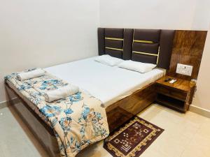ein Schlafzimmer mit einem Bett mit einem hölzernen Kopfteil in der Unterkunft Radhe Krishna Homestay in Varanasi