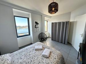Un dormitorio con una cama con dos toallas encima. en Bel appartement de 105m2 VUE RIA d'ETEL, en Étel