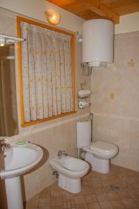 a bathroom with a sink and a toilet and a window at Zidanica Krošelj in Raka