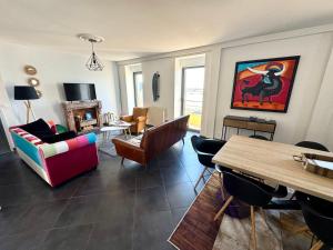 una sala de estar con un sofá y una mesa en Bel appartement de 105m2 VUE RIA d'ETEL, en Étel