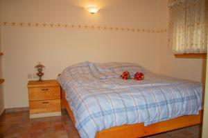 a bedroom with a bed with two red roses on it at Zidanica Krošelj in Raka