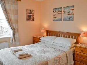 a bedroom with a bed with two night stands and a window at Middle Cottage in Thirsk