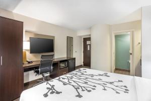 a hotel room with a bed and a desk and a television at Sleep Inn near Penn State - State College, PA in State College