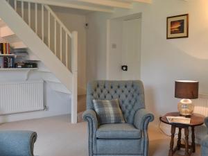 - un salon avec une chaise et un escalier dans l'établissement Sunny Cottage, à Bulmer