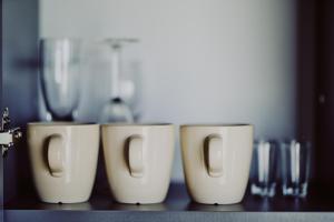 four coffee cups are lined up on a table at Domki Dollar -Plaża Nowe Guty in Nowe Guty +18 photos