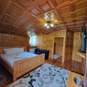 a bedroom with a bed and a wooden ceiling at Casa Mariflor in Vama Buzăului