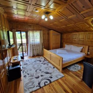 une chambre avec un lit et un plafond en bois dans l'établissement Casa Mariflor, à Vama Buzăului