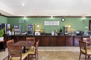 a restaurant with a table and chairs and a counter at Sleep Inn & Suites Bush Intercontinental - IAH East in Humble