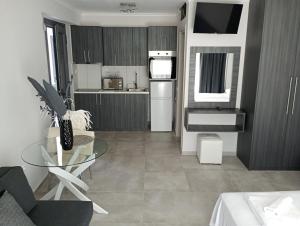 a kitchen with a glass table in a room at Alivka Apartments in Apolpaina