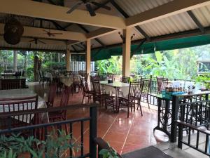 an empty restaurant with tables and chairs on a patio at IngNatee Resort in Pathum Thani