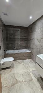 a bathroom with a tub and a toilet and a sink at Le luxe MENZAH5 in Ariana