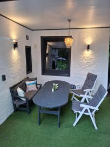 a patio with a table and chairs and a mirror at Ferienzimmer by Riela im ehemaligem Hotel Schöneck in Schönecken