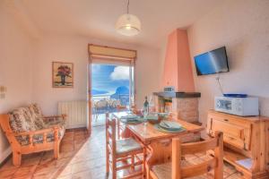 een woonkamer met een eettafel en een televisie bij Residence Bellevue in Tremosine Sul Garda