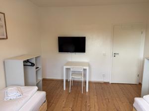 a room with a table and a tv on the wall at T&K Apartments - Nettetal - 3 Zimmer Wohnung - Privatparkplatz - 6 km bis Venlo in Nettetal
