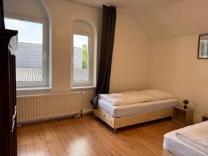 a bedroom with a bed and two windows at T&K Apartments - Nettetal - 3 Zimmer Wohnung - Privatparkplatz - 6 km bis Venlo in Nettetal