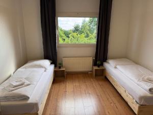 two beds in a room with a window at T&K Apartments - Nettetal - 3 Zimmer Wohnung - Privatparkplatz - 6 km bis Venlo in Nettetal