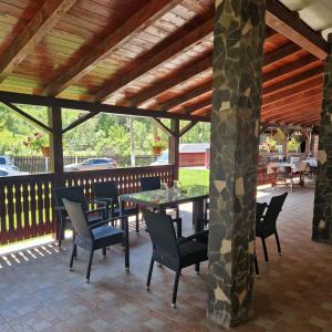 un patio avec une table et des chaises dessus dans l'établissement Casa Mariflor, à Vama Buzăului