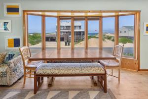 - une salle à manger avec une table et des chaises offrant une vue sur la plage dans l'établissement 4080 - Betcha Like It, à Kitty Hawk