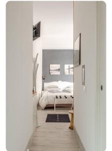 a white bedroom with a bed and a mirror at Merano appartamento in Merano