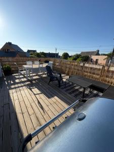 eine Terrasse mit Tischen und einer Bank und einem Tisch in der Unterkunft Charmante Maison Néo-bretonne in Perros-Guirec