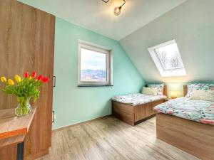 a bedroom with two beds and a vase of flowers at Miodomki in Brenna