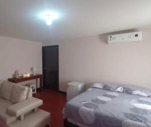 a bedroom with a bed and a chair and a desk at Flowers House Aptos - Centro Histórico in Valledupar