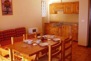 a kitchen with a wooden table with chairs and a dining room at Residence Bellevue in Tremosine Sul Garda