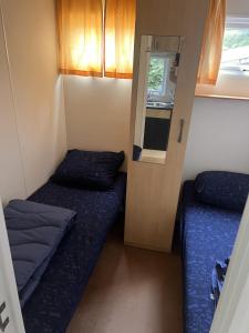a small room with two beds and a mirror at KD 743 - Vakantiepark Kijkduin in The Hague