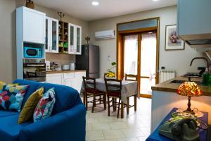 a living room with a blue couch and a kitchen at Luc's Home in Frattaminore