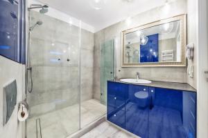 een badkamer met een blauwe wastafel en een douche bij Perfect Apartment Chmielna Park in Gdańsk