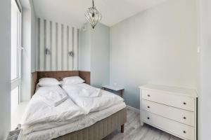 een kleine slaapkamer met een bed en een dressoir bij Perfect Apartment Chmielna Park in Gdańsk