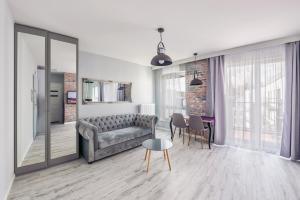 een woonkamer met een bank, een tafel en stoelen bij Perfect Apartment Chmielna Park in Gdańsk