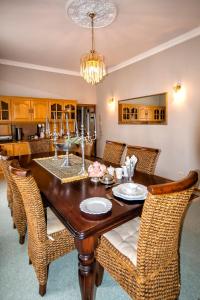 a dining room with a wooden table and wicker chairs at Sewende Hemel in Kroonstad