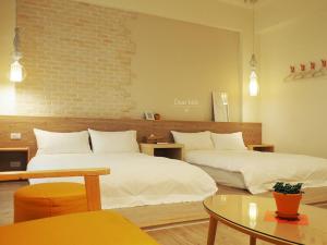 a hotel room with two beds and a table at Daybreak in Taitung City