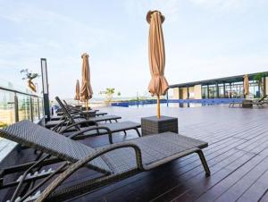 KangboiにあるLenggo - Apartement Meisterstadt Pollux Habibie 52-05のパティオに置かれた椅子とパラソルのグループ