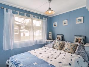 a blue bedroom with a bed and a window at Bluebird Chalet - Uk38524 in Mundesley +9 photos