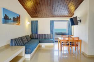 ein Wohnzimmer mit einem Sofa, einem Tisch und Stühlen in der Unterkunft 3HB Golden Beach in Albufeira