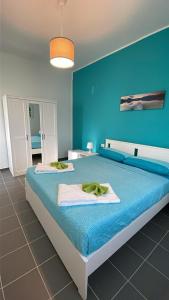 a blue bedroom with a bed with towels on it at A 100 passi dal mare in Bari +7 photos