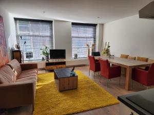 ein Wohnzimmer mit Sofa und Tisch in der Unterkunft Stadslogement Bij de Sassenpoort in Zwolle