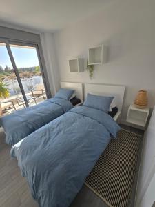 2 bedden in een slaapkamer met een groot raam bij Appartement Mijas in Mijas Costa +26 foto's