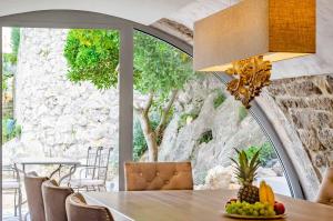 a dining room with a table with fruit on it at Fantastic Seafront Villa 4 Bedrooms Villa Samostan Prestige Stunning Sea Views & Enclosed Garden With Private Pool Korcula in Korčula