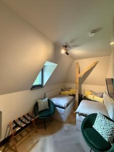 a attic room with two beds and a window at außergewöhnliche Ferienwohnung Stadtvilla Plauen in Plauen