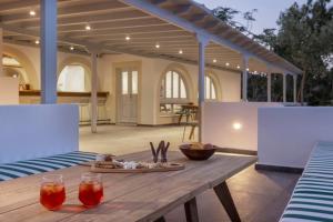 a wooden table with two glasses on a patio at Panorama Serenity Suites in Patmos