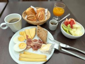 ein Teller mit Frühstücksessen mit Eiern, Speck und Obst in der Unterkunft Hotel Chantereyne in Cherbourg en Cotentin