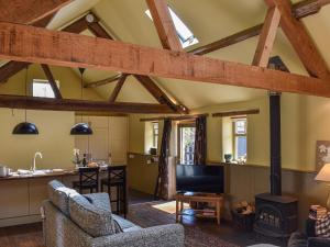 a kitchen and living room with wooden beams at The Byre in Helmsley