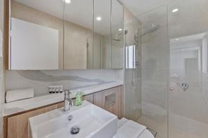 悉尼Modern 2BR with Sea and Sky View的带水槽和淋浴的白色浴室 更多11张照片
